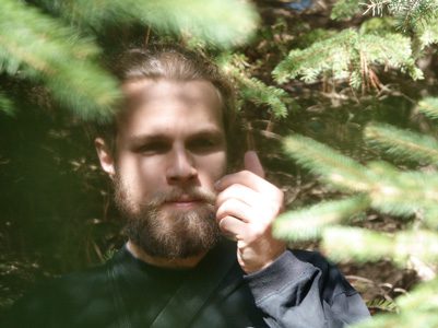 Man standing among tree branches.