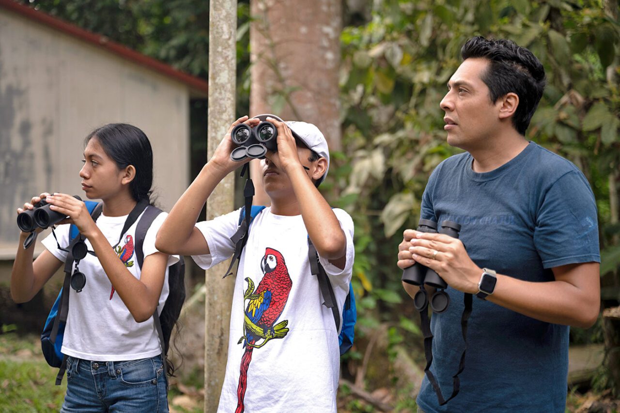 A man and two children with binoculars.