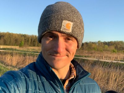 Man wearing a knit hat smiling.